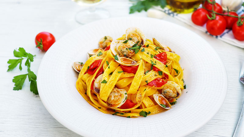 piatto di tagliatelle alle vongole con pomodorini